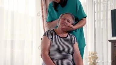 年轻的理疗师<strong>护士</strong>在家中或敬老院为老年妇女进行头部按摩的慢动作手持动作